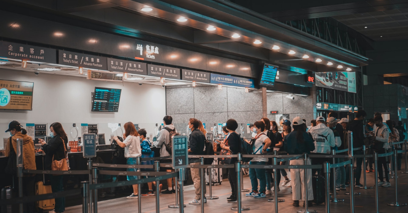 People queue up at an airport at check-in